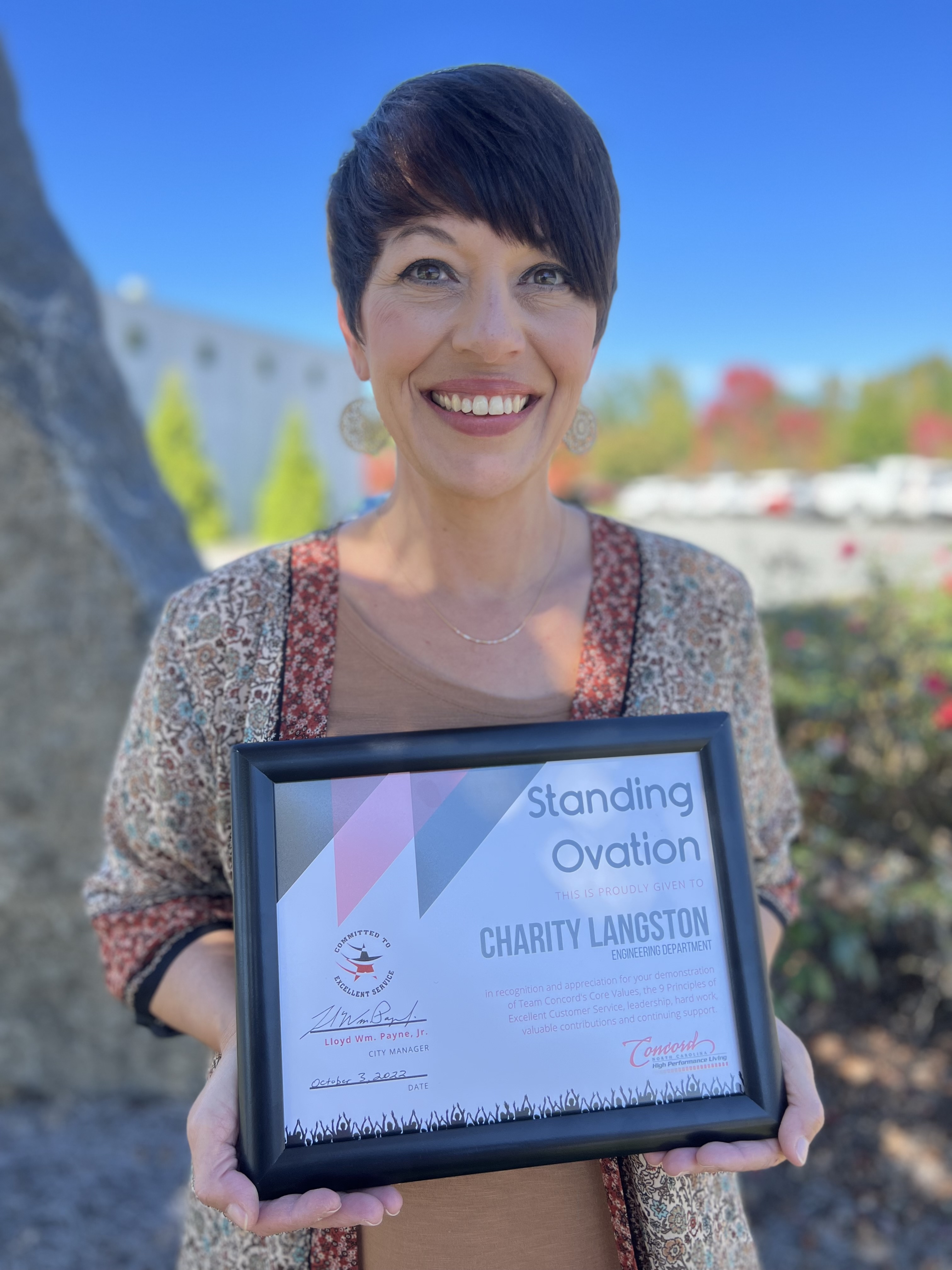 Charity Langston holding Standing Ovation Award Certificate